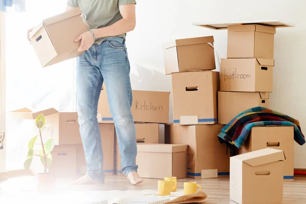 Человек, несущий картонные коробки в новый дом в день переезда — стоковое фото