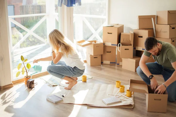 Par i ny lägenhet packa upp pappkartonger — Stockfoto