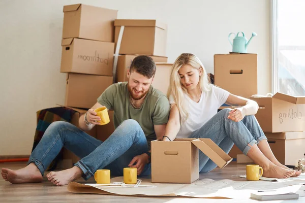 Koppel in nieuw appartement uitpakken kartonnen dozen — Stockfoto