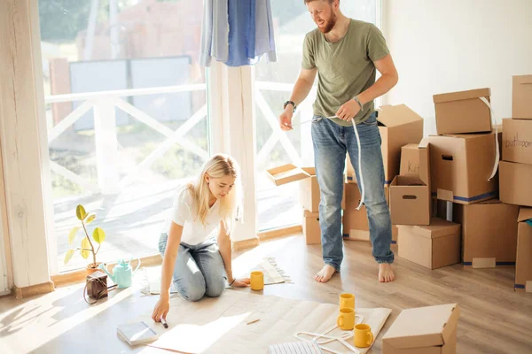 Pareja buscando planos de su nueva casa. Planificación del diseño de interiores — Foto de Stock