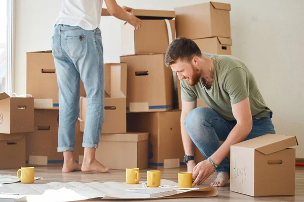 Casal procurando plantas de sua nova casa. Planejamento de interiores — Fotografia de Stock