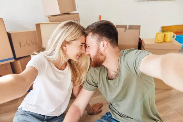 Para przenosi się do nowego mieszkania razem relokacja i robienie selfie — Zdjęcie stockowe