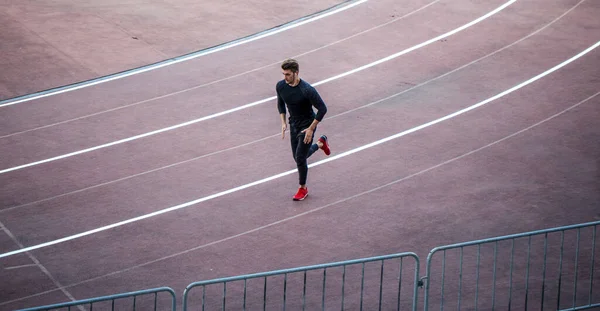 Top view Athlete running on running track. Runner sprinting on red running track in stadium — Stock Photo, Image