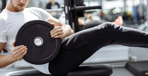 Muskelprotz beim Bauchmuskeltraining in einem modernen Fitnessstudio. Fitter Mann knirscht im Fitnessstudio. — Stockfoto