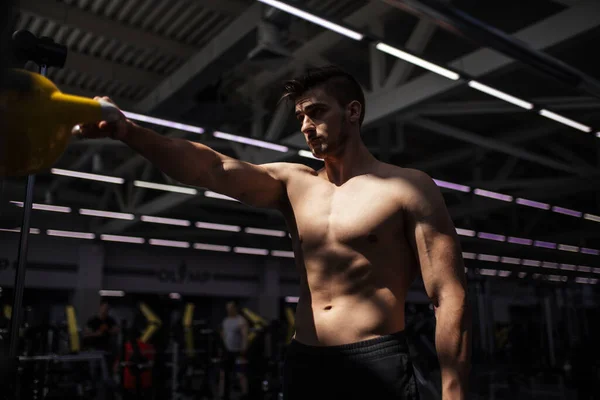 Jovem fitness homem é formação por kettlebell. — Fotografia de Stock