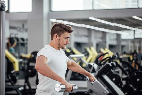 Fisiculturista realizando exercício com mashine treinamento ginásio — Fotografia de Stock