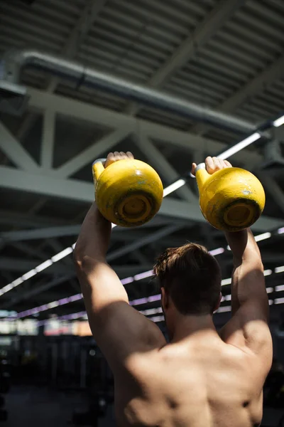 Young fitness man is training by kettlebell. — Stock Photo, Image
