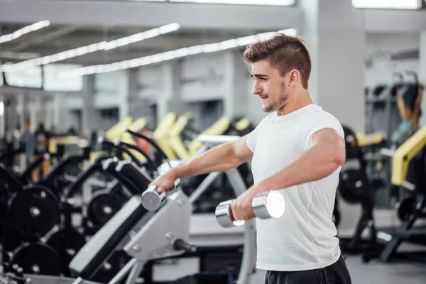 Fisiculturista realizando exercício com mashine treinamento ginásio — Fotografia de Stock