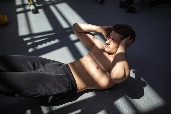 Muž na břišní křeče svaly cvičení během tréninku ve fitness tělocvičně. — Stock fotografie
