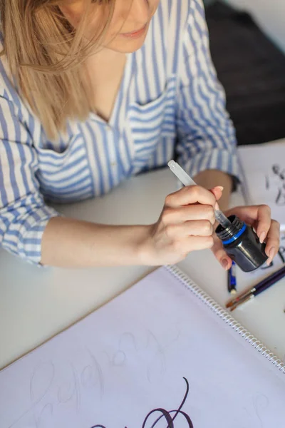 Ovanifrån av hand flicka med penna skriver på papper — Stockfoto