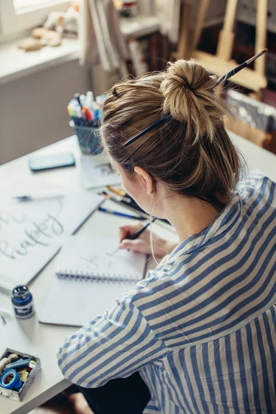 Vista dall'alto della mano della ragazza con penna scrive su carta — Foto Stock