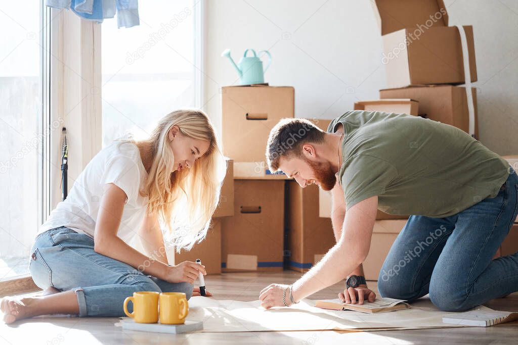 couple looking blueprints of they new house. Planning interior design