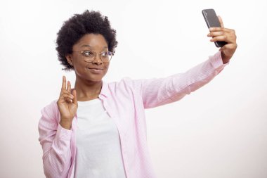 Elektronik cihaz kullanırken iki parmağını gösteren şık bir Afrika modeli