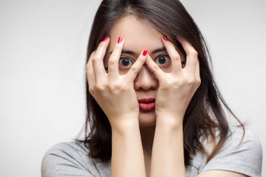 Genç Asyalı kadın ellerini korkuyla kapladı, izole edilmiş stüdyo çekimi.