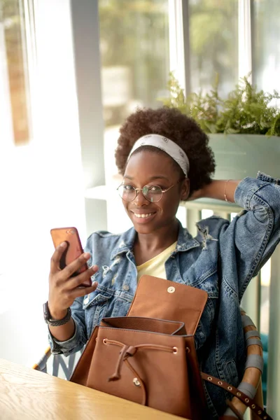 Afričanky americká žena s kudrnatými tmavými vlasy, dělá selfie, usmívá se do kamery — Stock fotografie