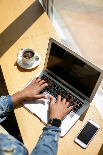 Manhã de trabalho de mulher de negócios Africano com um laptop e café, vista superior. — Fotografia de Stock