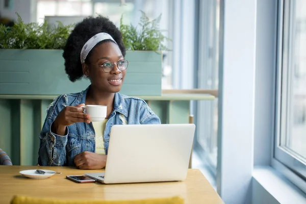 Blogueira africana, digitando um novo post durante a hora do almoço em um café. — Fotografia de Stock