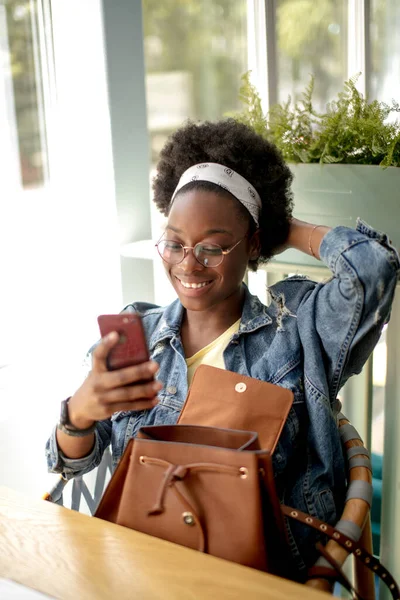 Afroamerikanerin mit krauses dunkles Haar, macht Selfie, lächelt in die Kamera — Stockfoto