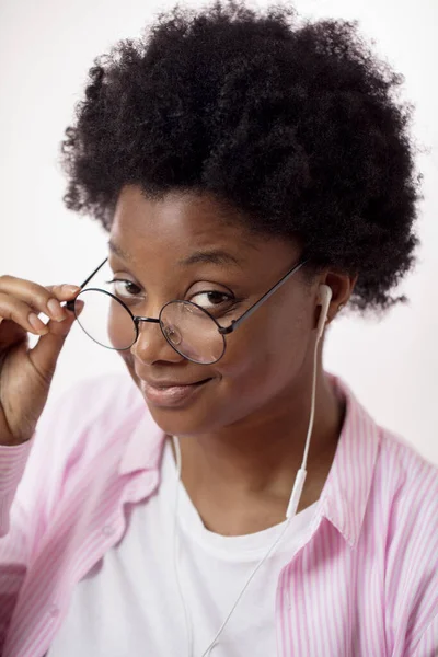 Modell mit Brille und Kopfhörer, lässig gekleidet und in die Kamera blickend — Stockfoto