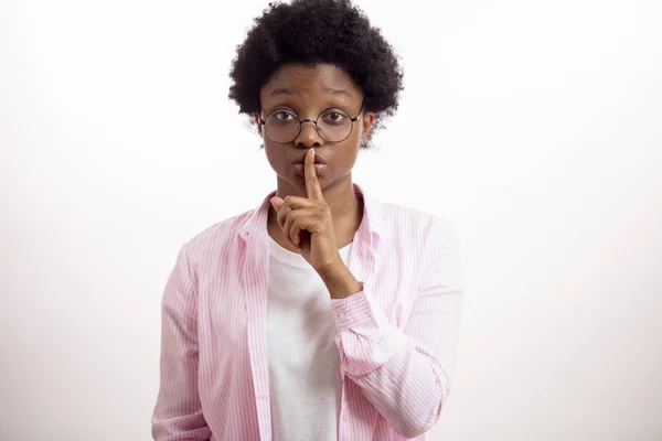 Hinreißende afrikanische Dame mit einem Finger auf den Lippen. Schweigen halten. — Stockfoto