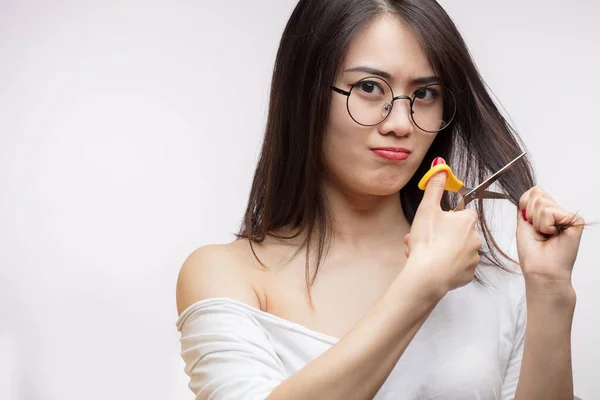 Zdenerwowany Azji dziewczyna mając problemy z długimi włosami, cięcia końce z nożyczkami — Zdjęcie stockowe