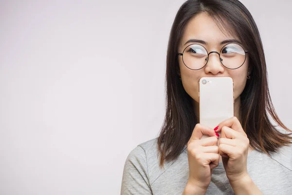 Modern akıllı telefonu elinde tutan Asyalı kadın stüdyoda beyaz arka planda izole edilmiş. — Stok fotoğraf