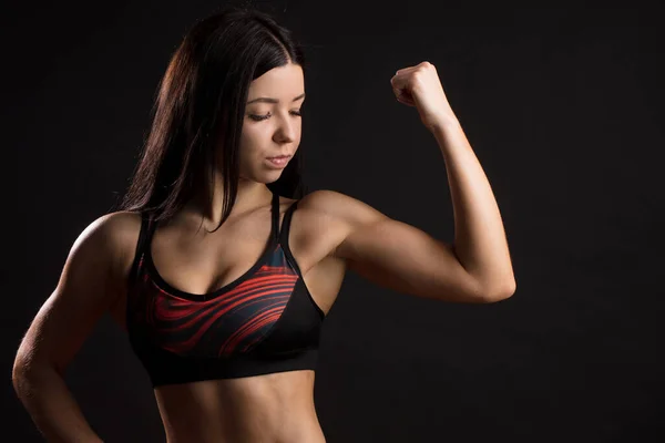 Instrutor de fitness feminino demonstrando corpo perfeito sobre fundo preto — Fotografia de Stock