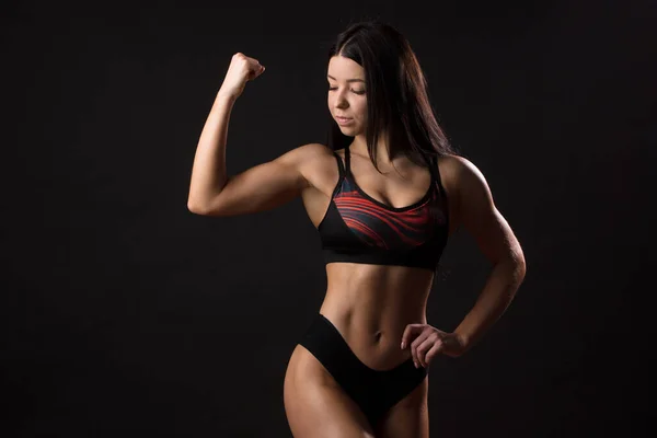 Női fitness oktató bemutató tökéletes test fekete háttér — Stock Fotó