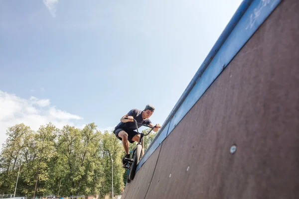 Freestyle. BMX rijder glijdt op de fiets op de helling in skate park. Straatcultuur — Stockfoto