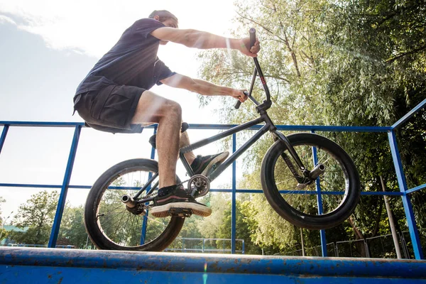 Man fietst op het achterwiel van BMX. mannelijke rijder maakt trucs op BMX fiets — Stockfoto