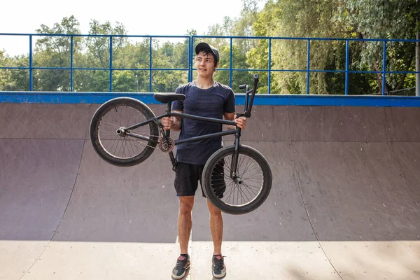 頭部の上にbmx自転車を持ちカメラで微笑む男 — ストック写真