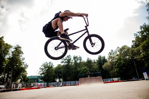 Boy jumping with his street-bike bmx in skate park