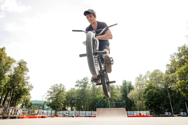 Jongen springt met zijn street-bike bmx in skate park — Stockfoto