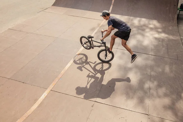 BMX велосипедист делает трюк на своем велосипеде — стоковое фото