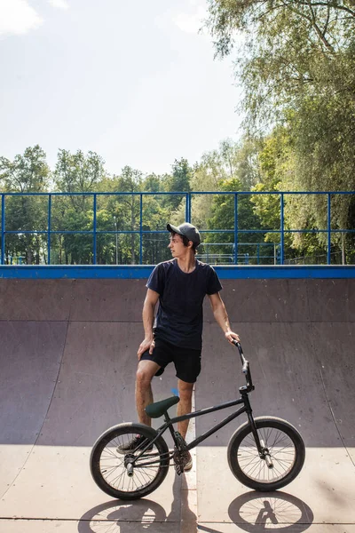 Jeune homme avec vélo BMX se tient sur la rampe. Culture de rue — Photo