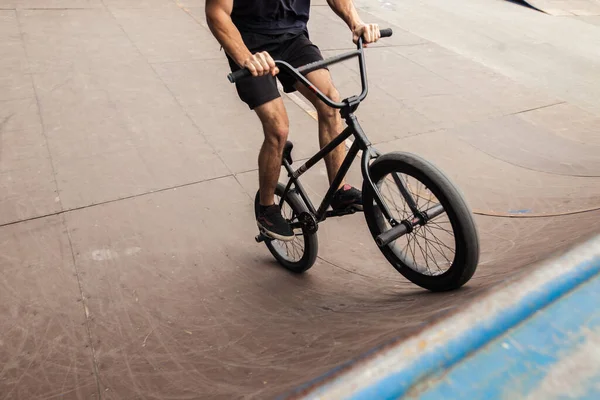 Freestyle male rider riding in skate park on bmx