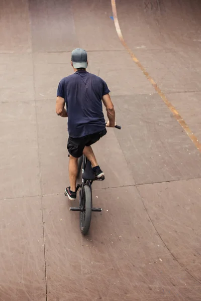 Freestyle male rider riding in skate park on bmx