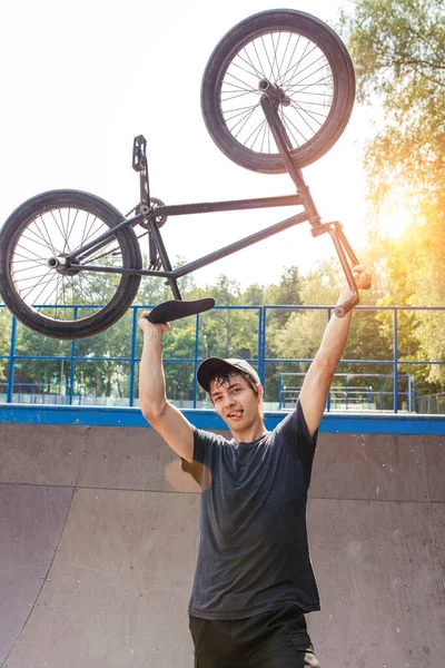 Homme tenant bmx vélo au-dessus de la tête et souriant à la caméra — Photo