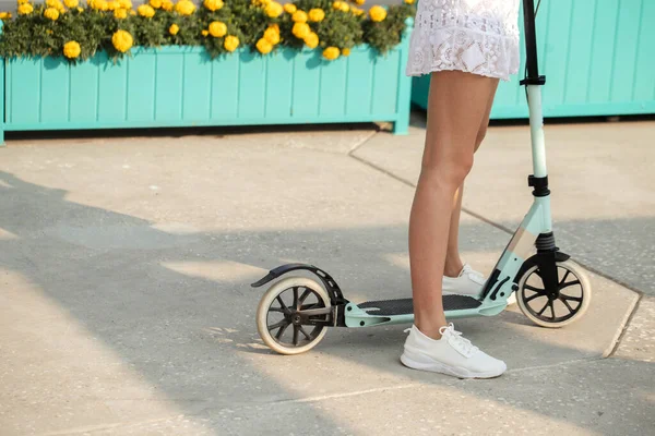Close up Woman legs on blue kick scooter on road at summer day — Stock Photo, Image