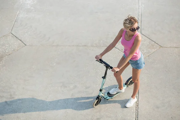 Menina bonita poising no verão na cidade e ao lado de scooter pontapé azul — Fotografia de Stock