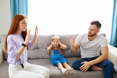 üzgün, çaresiz küçük kız ebeveynler tartışırken, kulakları tıkıyor