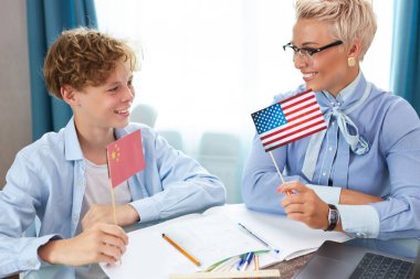 Kafkasyalı İngilizce öğretmeni kadın çocuğun evde ders almasına yardım ediyor.