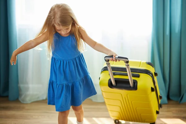 Feliz caucásico niña turista paquetes de ropa en una maleta para viajar, vacaciones — Foto de Stock