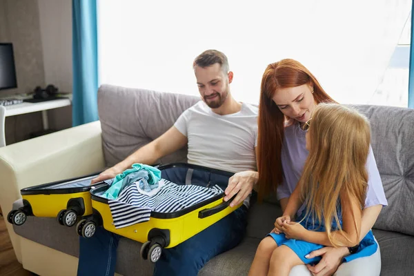 Hermosa familia caucásica con niño maleta de embalaje, va a viajar — Foto de Stock