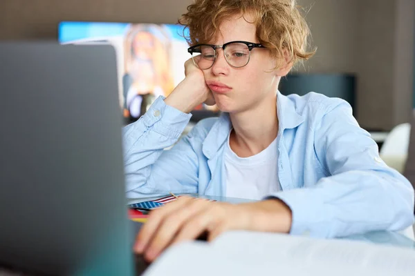 Retrato de niño caucásico cansado estudiando en casa — Foto de Stock