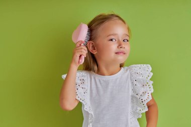 Çekici beyaz kız saçlarını tarıyor.