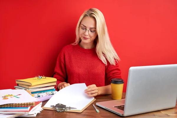 Retrato de mujer rubia caucásica confiada sentada en el escritorio de la oficina con el ordenador portátil y papeles — Foto de Stock