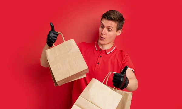 Bonito caucasiano entrega homem segurando saco de papel com takeaway comida — Fotografia de Stock