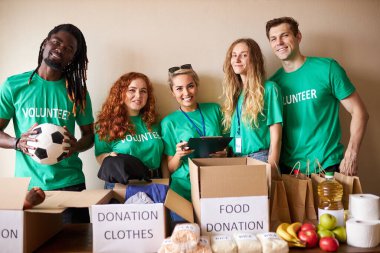 Çeşitli gönüllüler bağış kutusunda insani yardım topluyorlar.