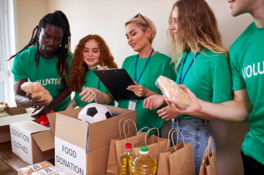Mutlu genç gönüllüler hayır kurumları için giysi ve yiyecek bağışlıyorlar.